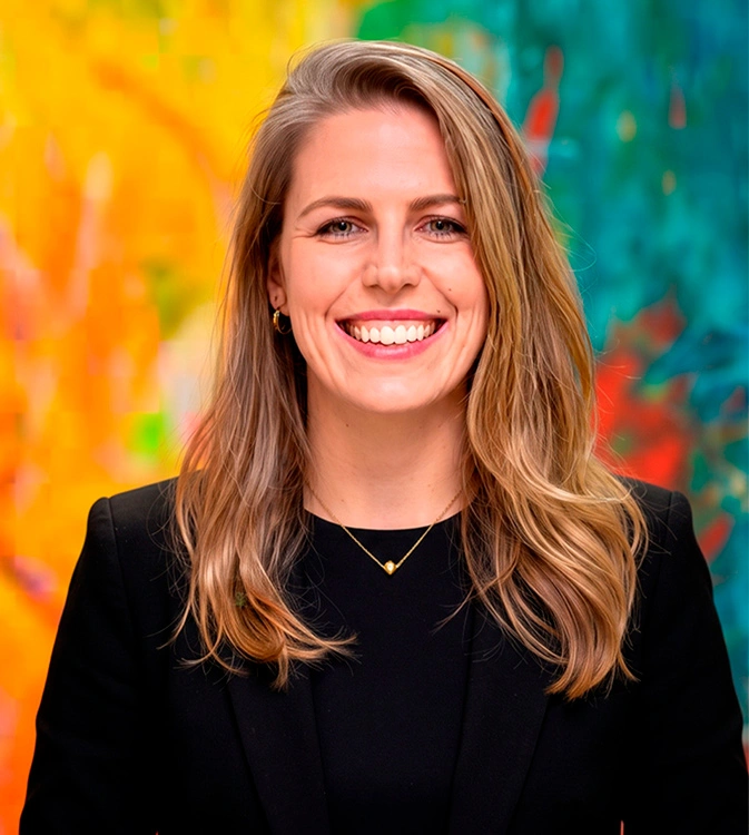 Fotografia profissional da psicóloga Marcia Caliman Margotto em seu consultório em Itabuna. Ela está sorrindo, vestindo trajes casuais finos, em um ambiente acolhedor e bem iluminado